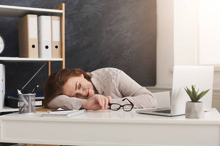在办公室用笔记本电脑工作时睡在工作场所的劳动期中图片