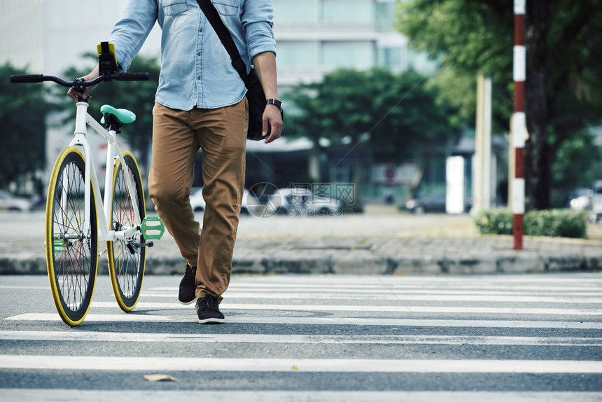 男人过路时走在自行车旁图片