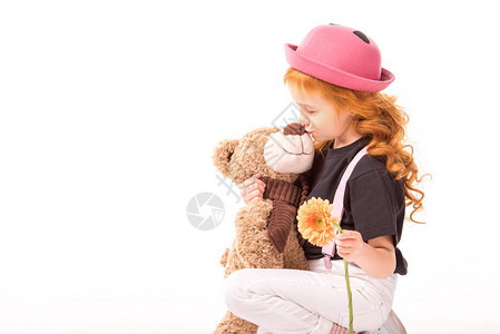 拿着花和亲吻泰迪熊的小孩图片