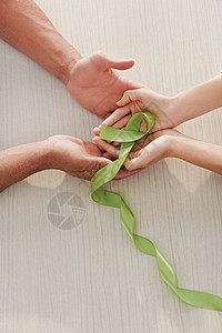 男和女手握绿丝带的剪影图片