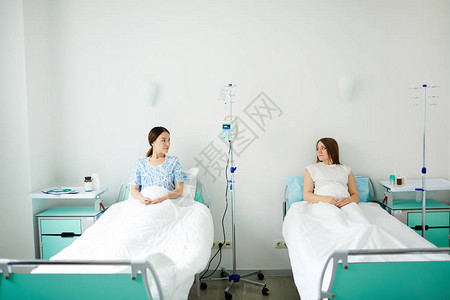 两名孕妇在病房的床上休息谈论孩子的抚养图片