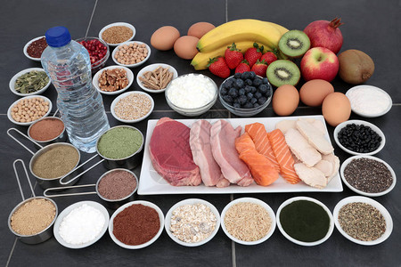 高蛋白瘦肉和鲑鱼的健美保健食品补充粉末水果坚果种子谷物豆类草药乳制品和瓶装背景图片