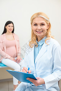 剪贴板和年轻孕妇的产科妇产科妇医生其图片