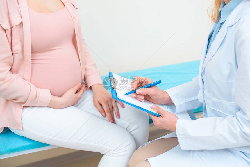 产科妇医生在诊所向孕妇咨询时拍图片