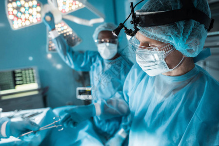 护士在手术室将医疗剪刀通过手术室外科医图片