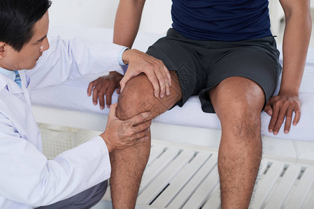 检查男运动员膝关节的医生图片