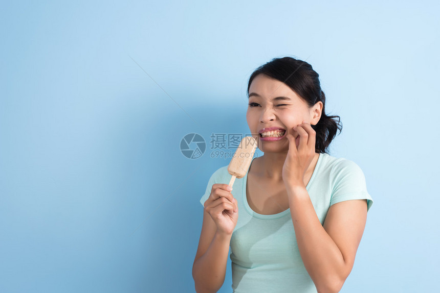 亚洲年轻女牙齿超敏感吃冰棒的亚裔女孩用复制图片