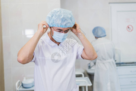 在准备手术期间的年轻医生医院手术室戴外科口罩的图片