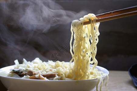 筷子从热气腾的碗里夹起米粉图片