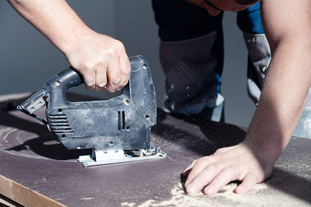 木工的特写手与专业切割工具线锯或拼图图片