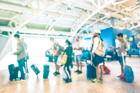在国际机场航站楼门口排队等候飞机旅行的模糊散焦人群图片