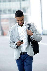 一名青年男子走路看手机的肖像图片