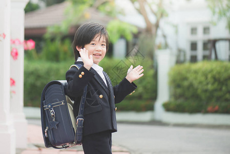 亚洲学生去上学和挥手告别图片