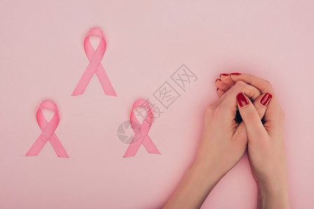女手和乳腺癌宣传带的作物观察以浅背景图片