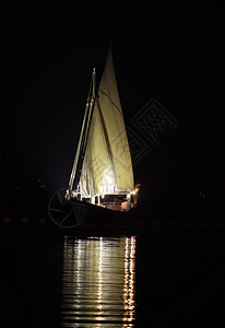 一艘阿拉伯单桅帆船及其晚帆在卡塔尔图片