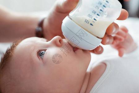从奶瓶婴儿瓶中喂养可爱婴儿的男图片