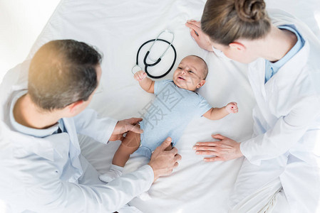 婴儿在床上玩耍的儿科医生图片