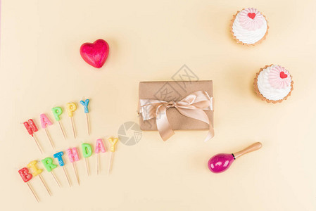 生日快乐信带丝的信封和粉红上美味的纸杯蛋糕图片
