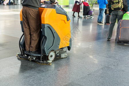 机场或火车站楼层护理和清洁服务局的男司机驾驶专业地板清洁机单图片