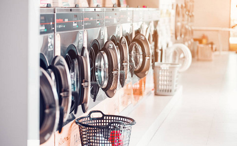 公共洗衣店的洗衣店里有一排工业洗衣机篮图片