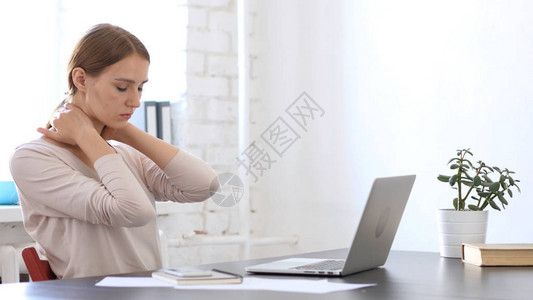 颈部疼痛漂亮的女人在办公室累了图片