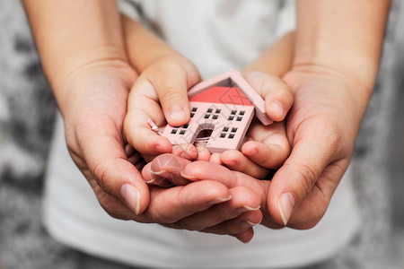 妇女和儿童手握房子模型图片