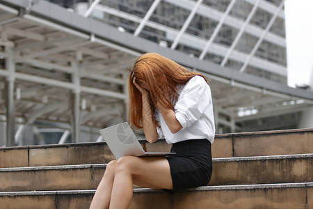 疲惫不堪的亚洲年轻女商人手牵对工作感图片