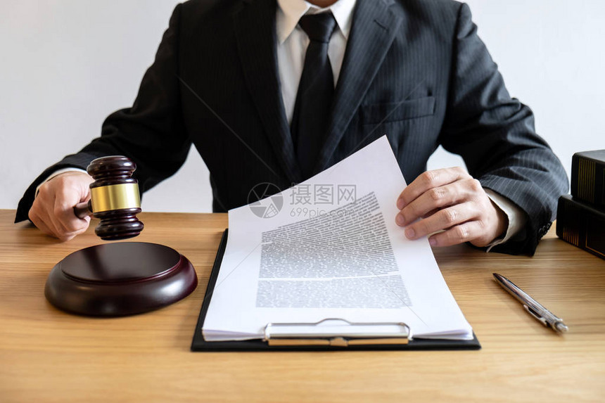 法律咨询和司法概念男咨询律师或公证人处理重要案件的文件和合同文件和木槌法图片