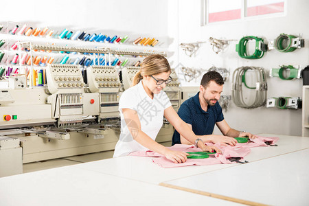两个人在一家纺织厂准备刺绣衣图片