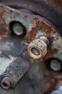 金属生锈背景上旧螺丝的特写图片