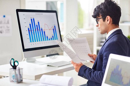商人按工作场所阅读文件并分析统计数据图片
