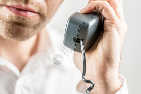 一个未洗发男子听电话交谈时将收音机握在手中图片