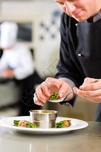 饭店或餐厅厨房师兼厨师他正在做盘图片