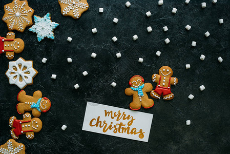 黑桌牌上自制姜饼棉花糖和圣诞快乐贺背景图片