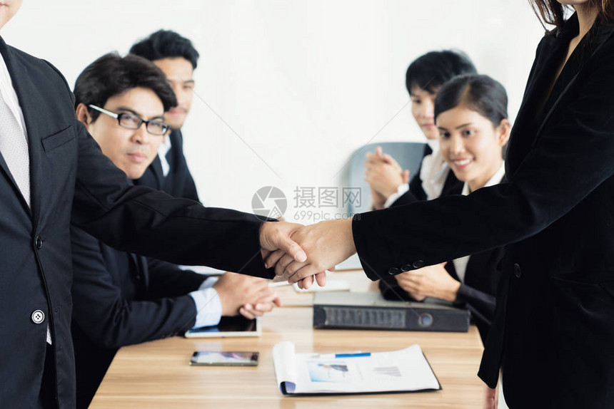 亚洲商人和女商人在会议室握手商界人士图片