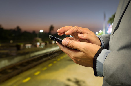 商人在黎明火车站使用移动电话电话图片