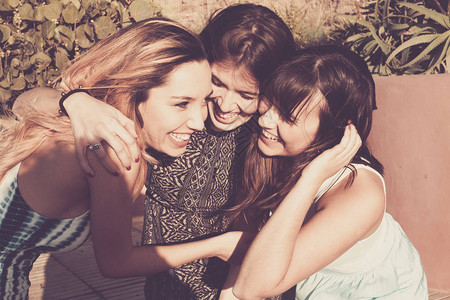 一群25岁的女孩在友谊团队中拥抱并欢笑在一起图片