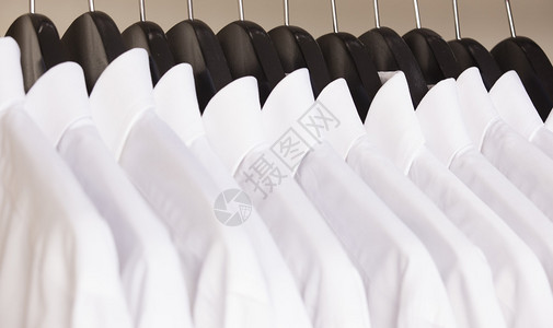一排带白衬衫的衣架图片