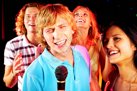 有趣的家伙在派对上唱歌的照片与快乐的女图片
