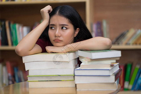 在教育概念图书馆阅读书或教科书的男孩学生感到图片