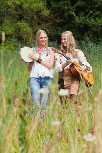 两个老金发70多岁的嬉皮女孩制作音乐用音响吉他和手鼓图片