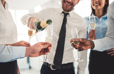 成功商业人士在办公室庆祝时喝香槟聊天和笑脸的刻画形象图片