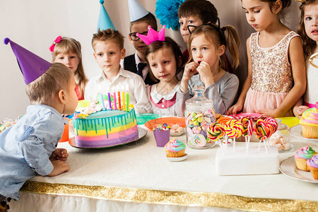 小孩庆祝生日男孩在吹蛋糕蜡烛之前许了个图片