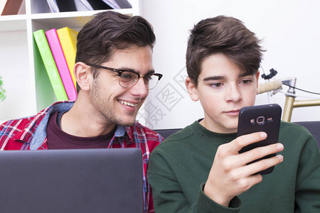 年轻人在家用电脑和手机背景图片