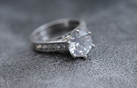 优雅的灰色皮革背景上的钻石戒指背景图片