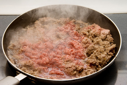 汉堡肉在炉子上的平底锅里变褐图片