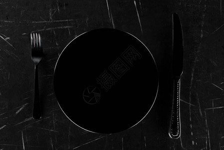 黑色圆板上方的黑圆形面用叉子和图片