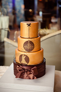 一个现代的复杂的婚礼蛋糕配有铜织品还有吊灯和舞伴合唱团的轮背景图片