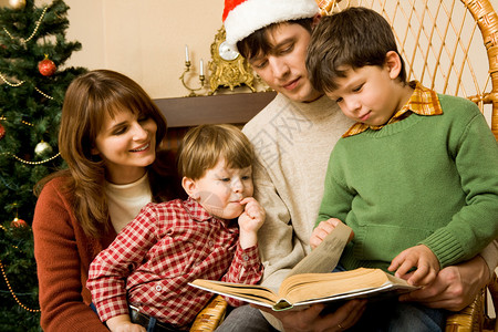 寻找圣诞日有趣书的友好家庭肖像在图片