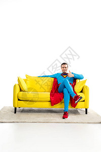 帅男超级英雄坐在沙发上在白图片